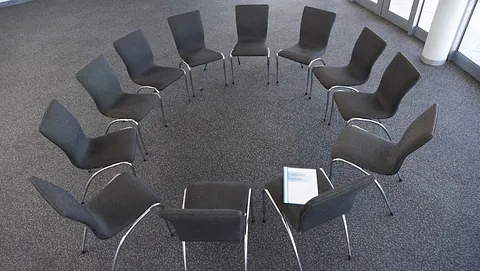 Stoler satt opp i sirkel i et møterom til kurs eller gruppesamtale